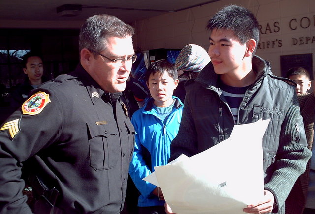 Sgt. Dave Seawell of the Calaveras County Sheriff's Department, receives a poster made by ERDT exchange student Jack Wei, 15, from China.