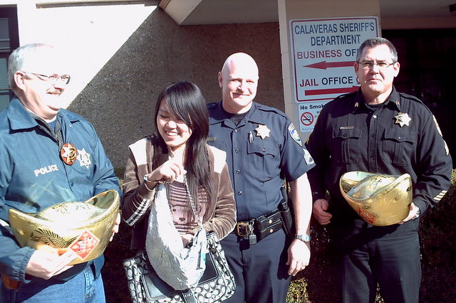 Hong Wang tries out her new handcuff handbag given to her from the Calaveras County Sheriff's Department.