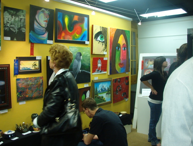 A wall sized view of several oil and acrylic paintings that adorn the walls of the gallery